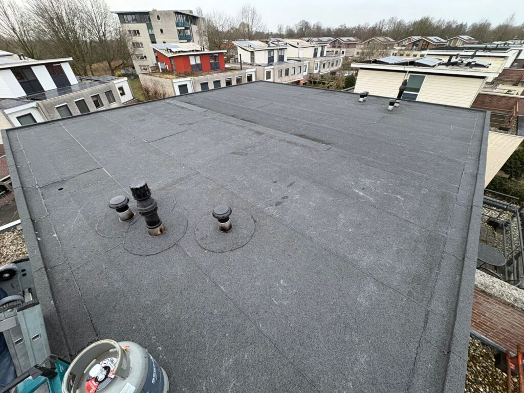 Plat dak in Naarden waar PVC is vervangen door bitumen dakbedekking met nieuw zinkwerk